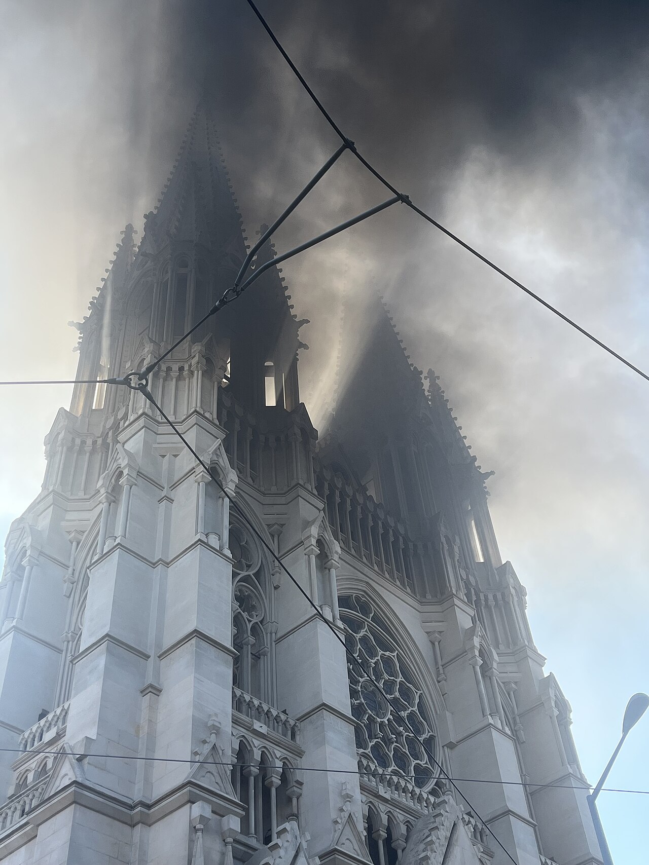 The twin towers of Marseille’s Réformés church partly obscured by smoke.